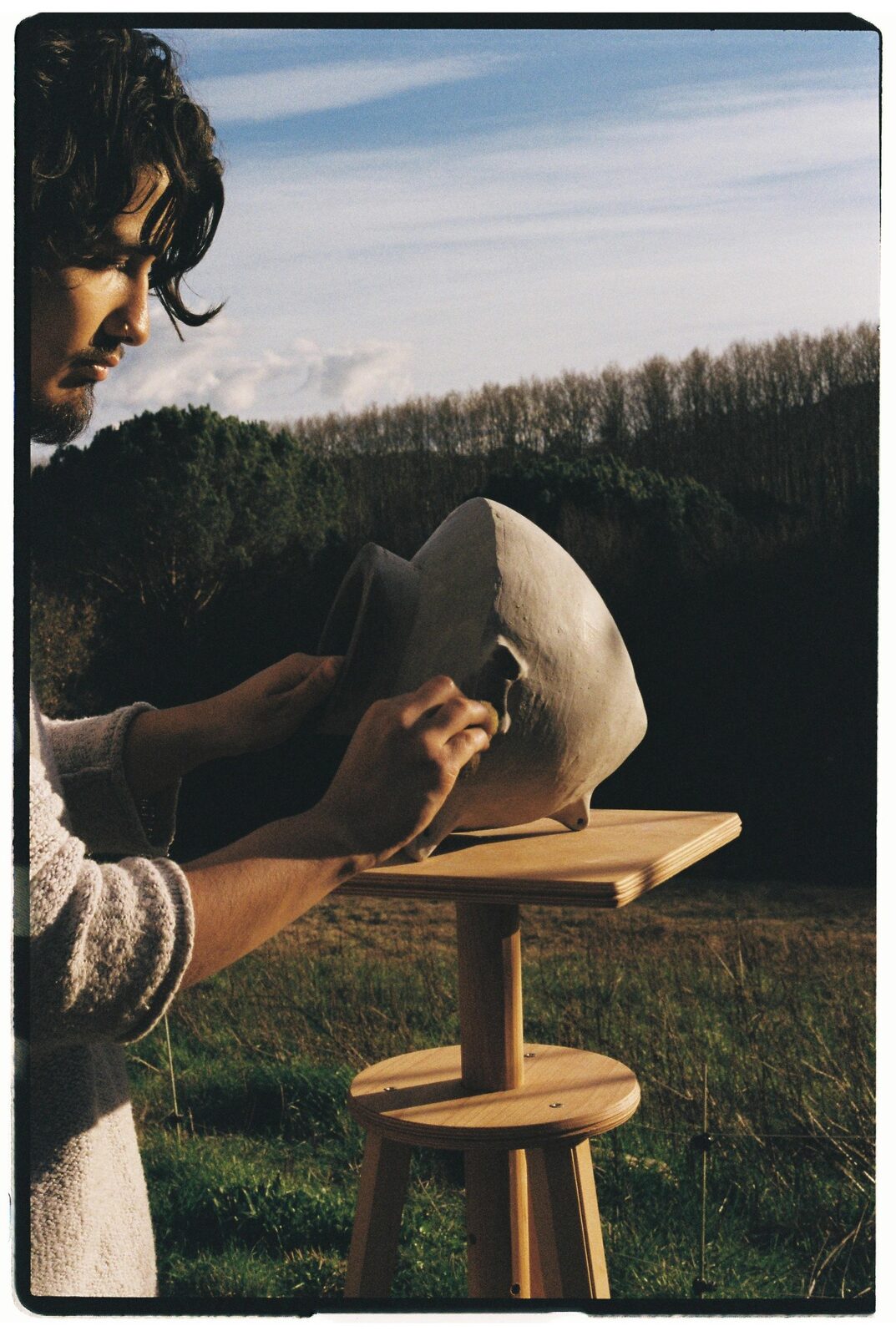 Artista trabajando una pieza escultórica al aire libre